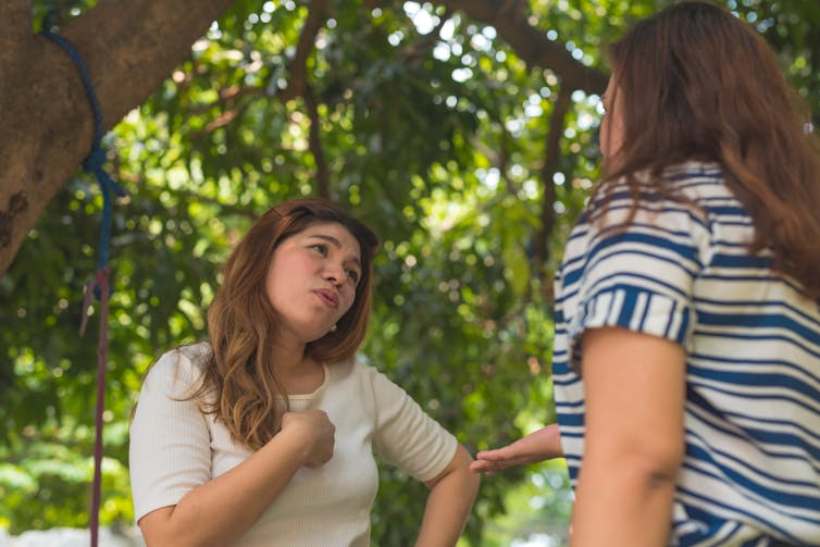 Two women appear to talk over each other.