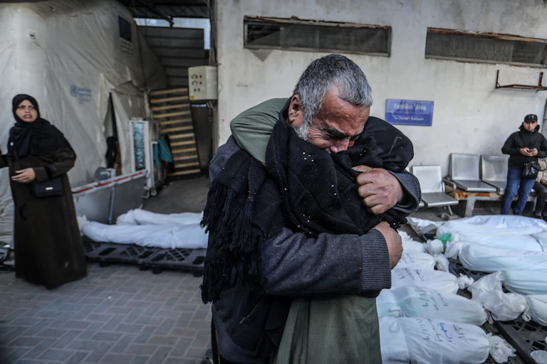 Two people hugging on the street.