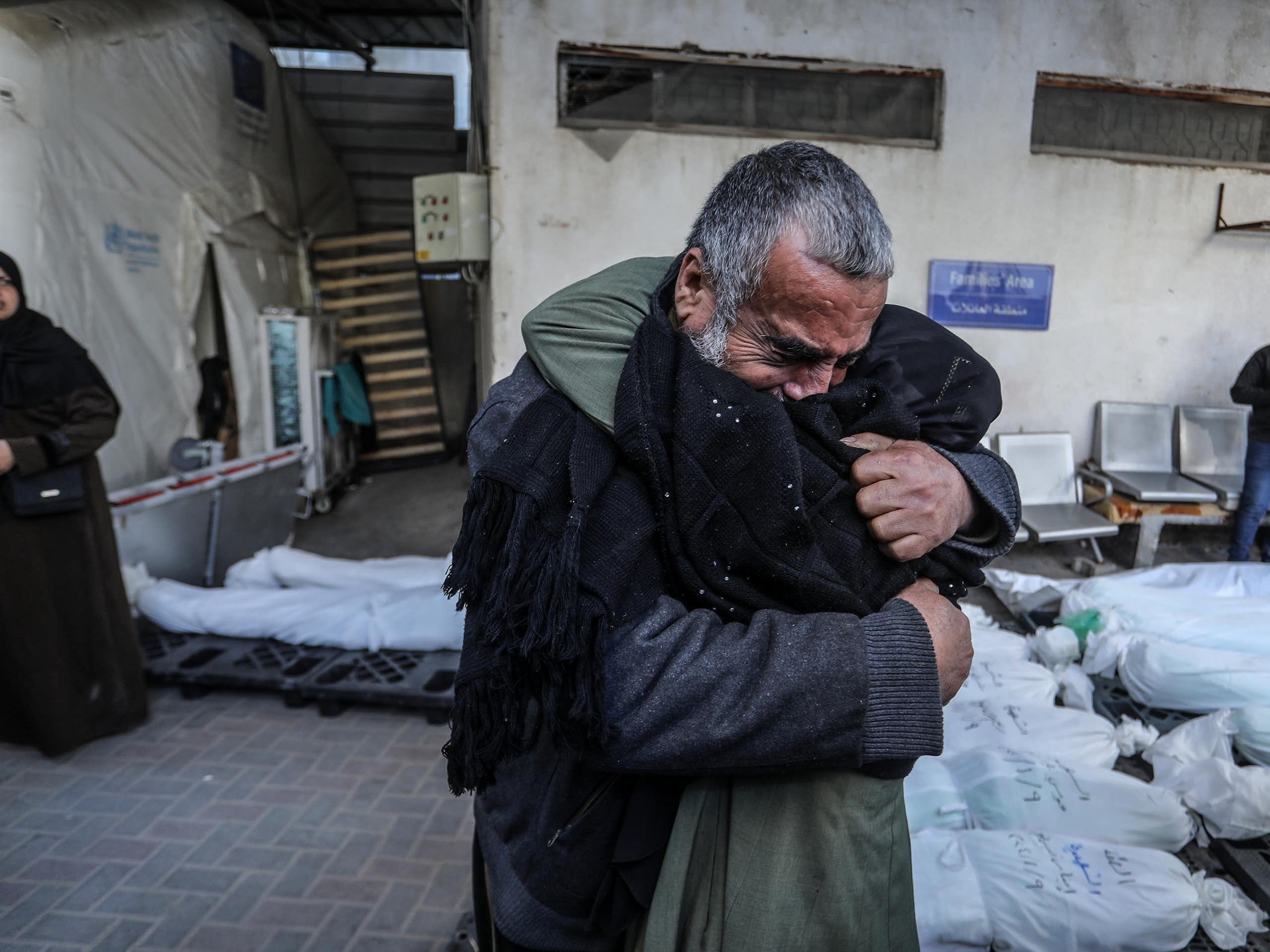 Two people hugging on the street.