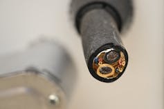 A severed cable stub protrudes from a charger