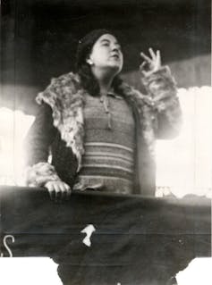 Una fotografía en blanco y negro de una mujer joven dando un mitin.