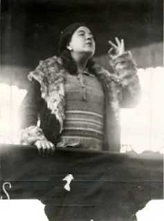 Una fotografía en blanco y negro de una mujer joven dando un mitin.