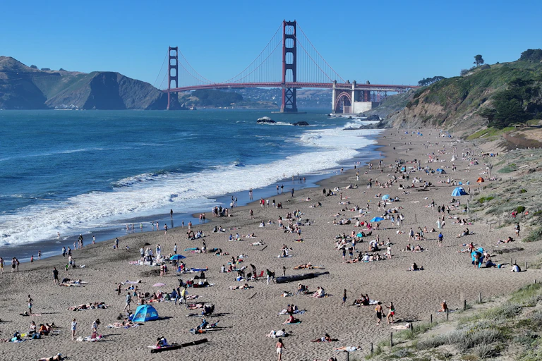 Aerial photo of beachgoers with the Golden Gate Bridge in the background