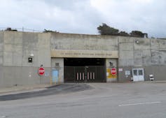 Vehicle entrance to a low-slung concrete building marked 'Oceanside Water Pollution Control Plant'