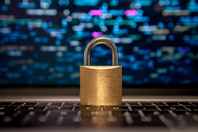 Security lock on a keyboard with blurred lines of data in the background.