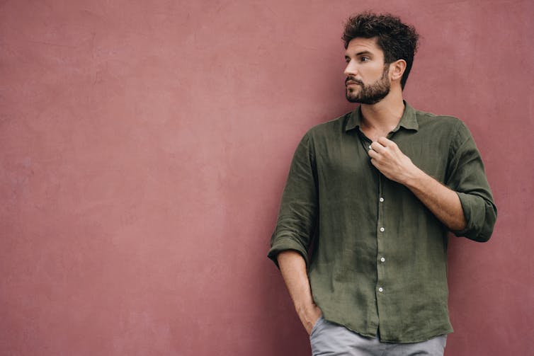 A man in a cotton shirt holds his button