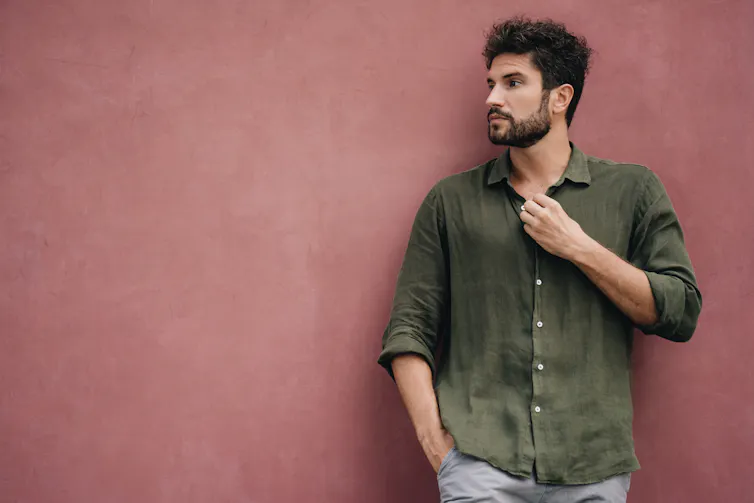 A man in a cotton shirt holds his button