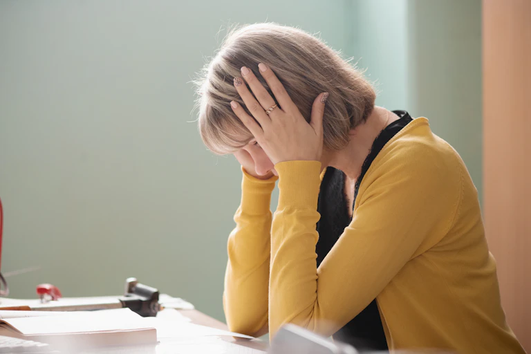 Woman with head in hands at desk