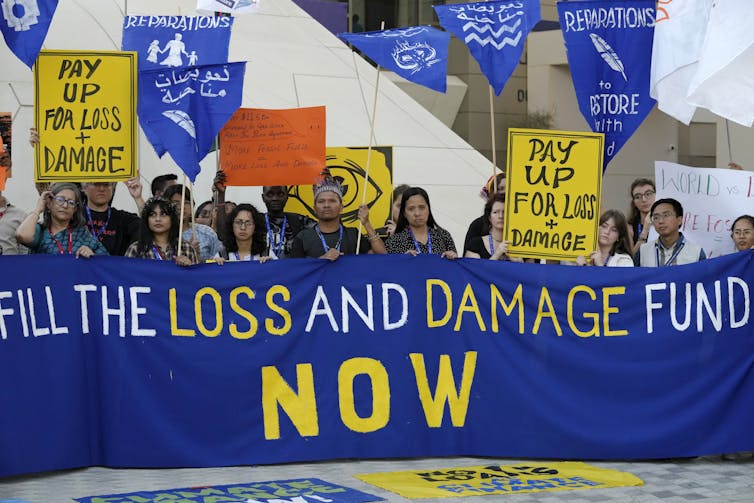 Activists stand in a row holding up a banner.