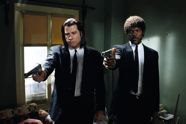 A scene shows two hitmen pointing guns at something offscreen.