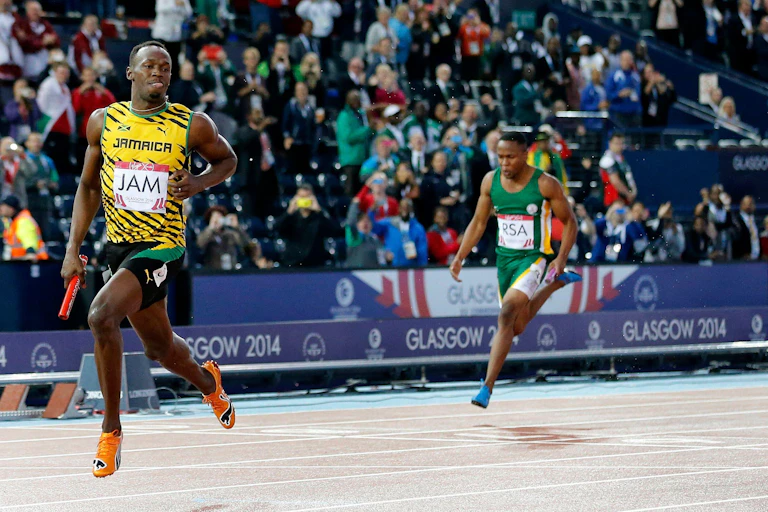 Jamaican athlete Usain Bolt crosses the line to win gold at the Glasgow 2014 Commonwealth Games