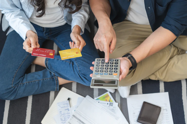 man and woman with credit cards and a calculator