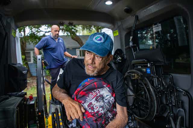 A man in a wheelchair waits for assistance in a specially equipped van ahead of Hurricane Milton's arrival in Florida.