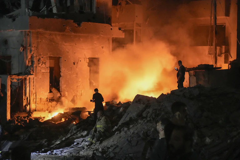 Flames and smoke rise at the scene of destroyed buildings hit by an Israeli airstrike in central Beirut, Lebanon