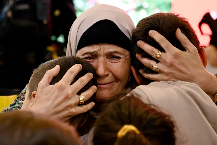 Family and friends embrace as Australian nationals arrive home on a repatriation flight from Lebanon via Cyprus
