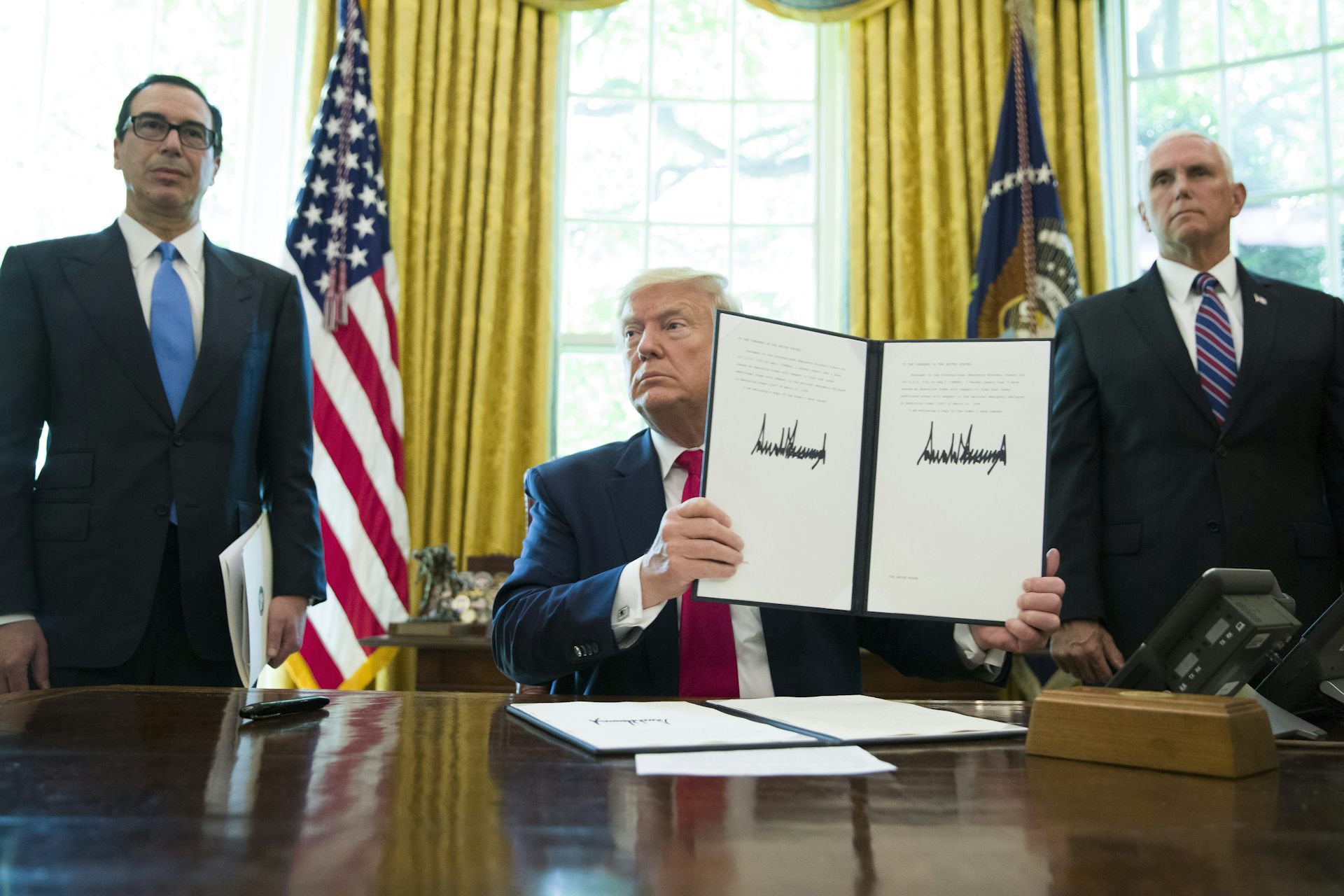 Donald Trump holding up an executive order.