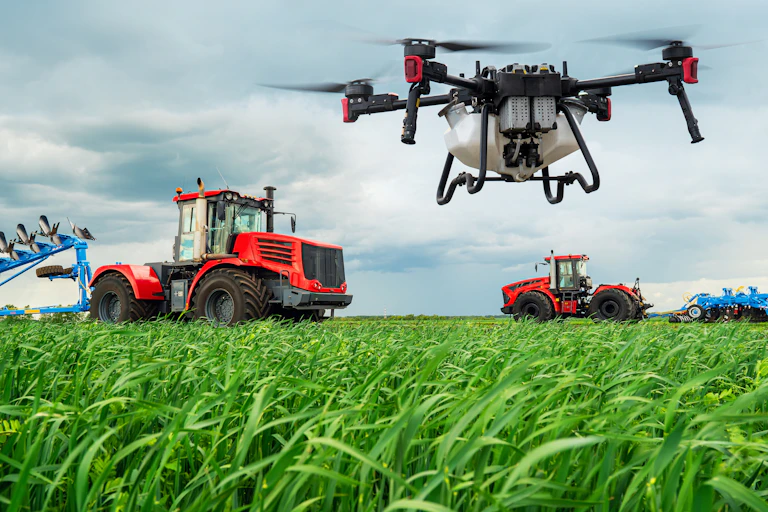 Un drone sourvole un champ dans lequel roule des tracteurs.