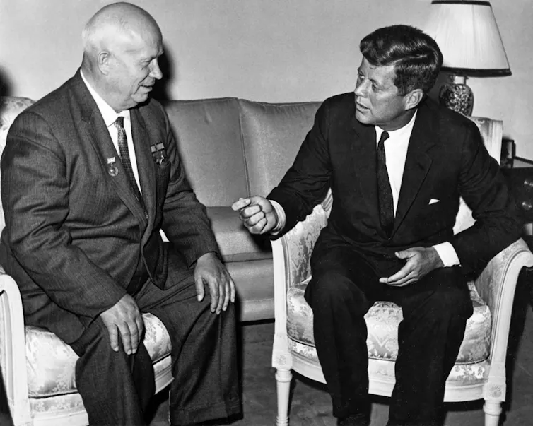 Soviet leader Nikita Kruschev sitting and talking with US president John F Kennedy in