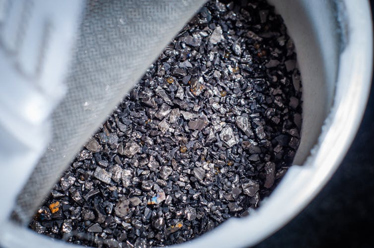 black fragments of carbon in a white container