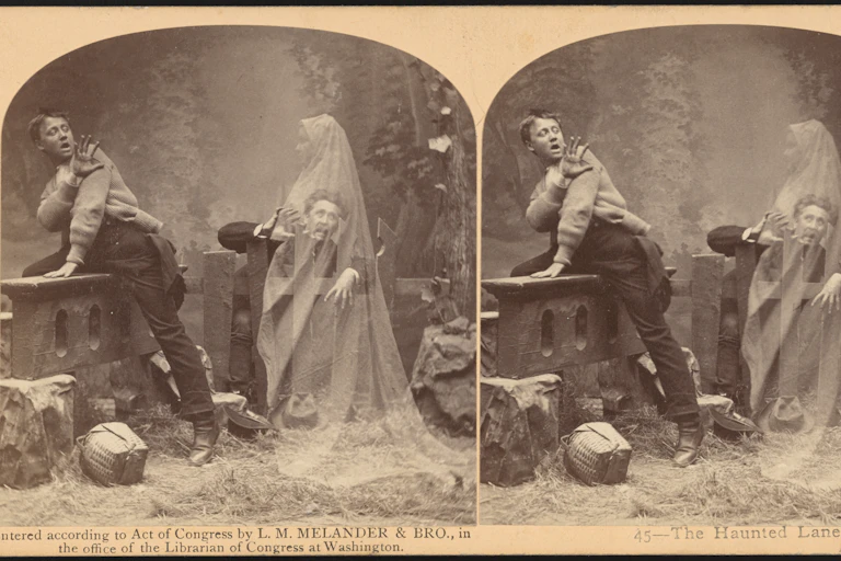 Two men standing near a gate cower in fear from a ghostly woman.