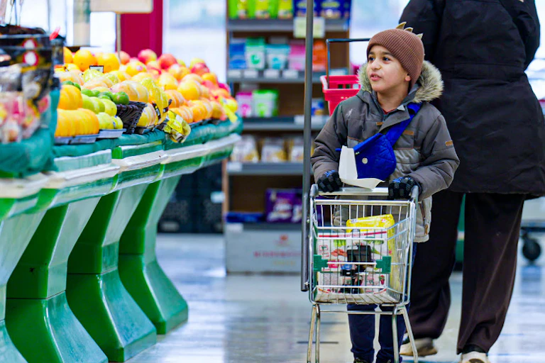 A child seen with a grocery cart.