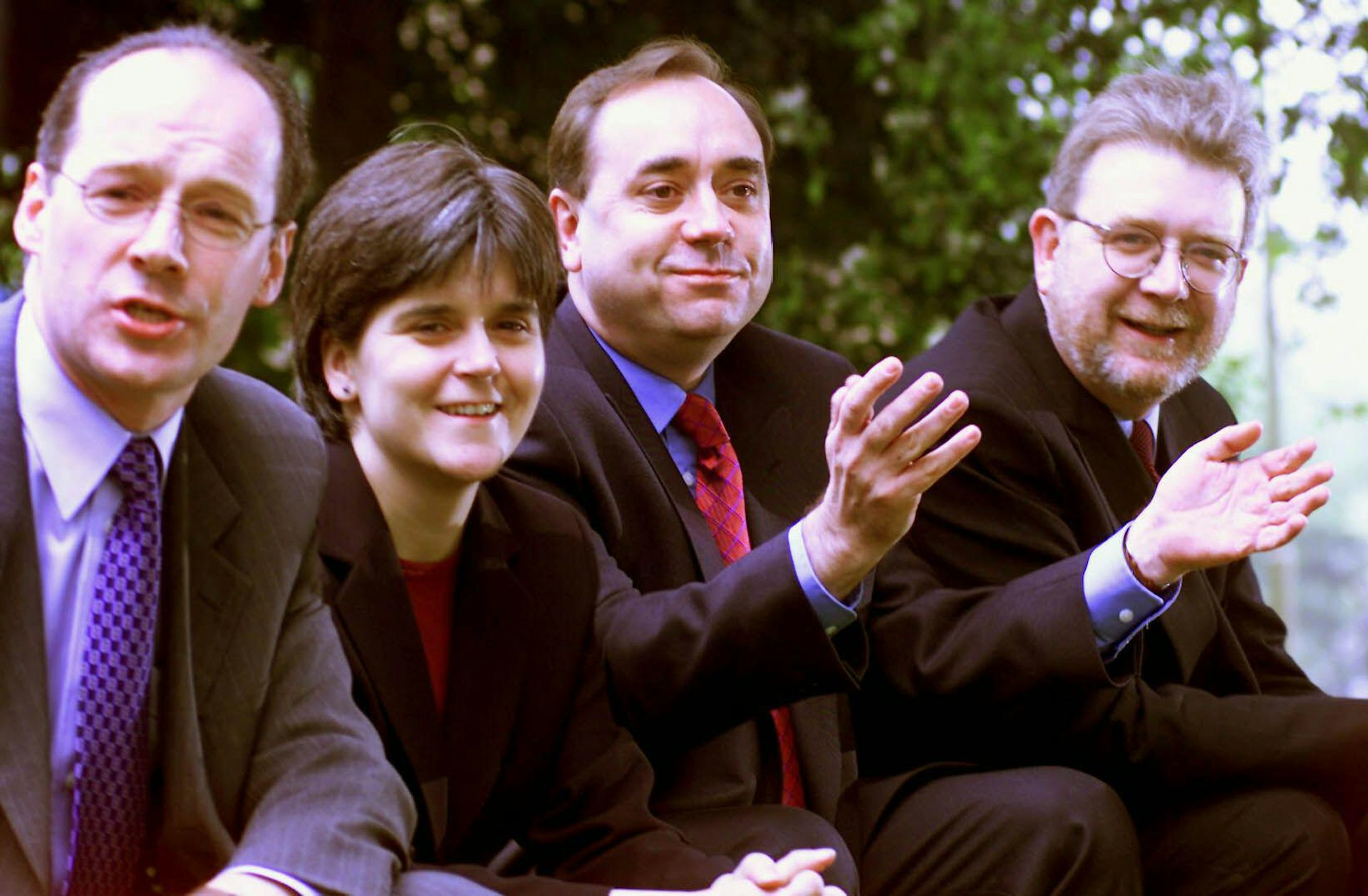 An old photo of John Swinney, Nicola Sturgeon, Alex Salmond and Mike Russell seated, smiling, wearing suits.