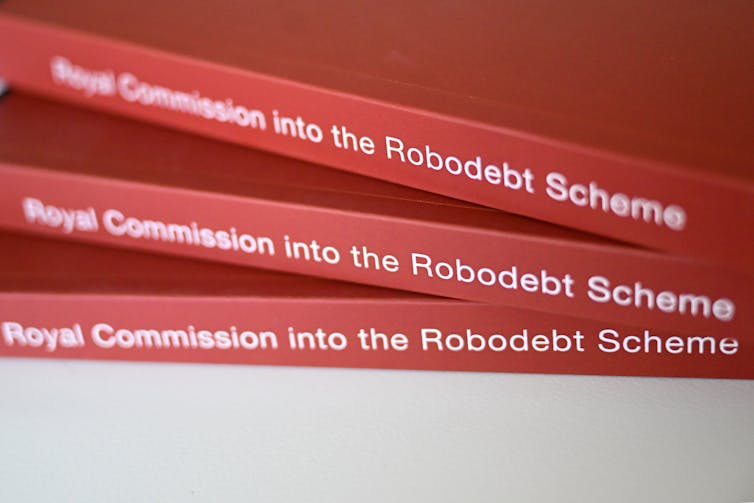 A close-up of three copies of the Royal Commission into the Robodebt Scheme