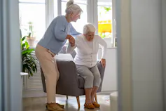 Woman helping another woman stand