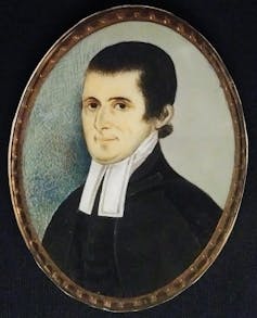 A painted portrait of a man with dark hair wearing a black coat, with a white necktie draped above it.
