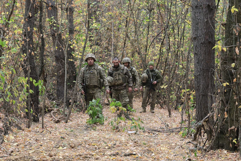 Ukrainian troops on patrol in a forest.