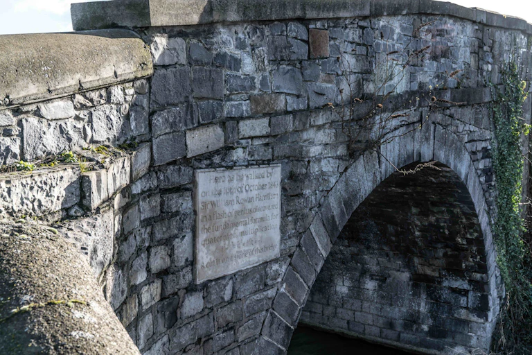 Photo of a stone bridge with a plaque on it.