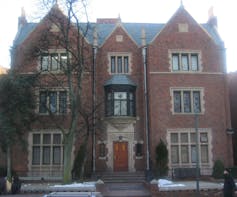 A three-story ornate brick building with stone trim and many narrow windows.