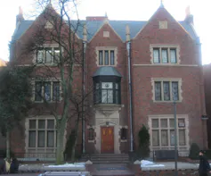 A three-story ornate brick building with stone trim and many narrow windows.