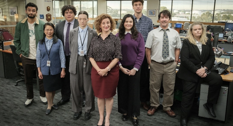 group of people stand in office