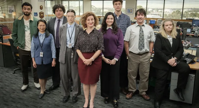 group of people stand in office
