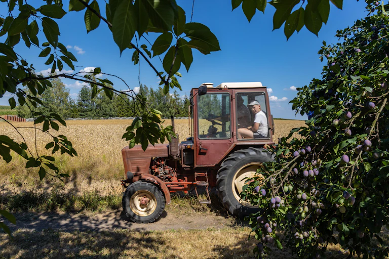 A Polish farmer sits in his tractor on a field.