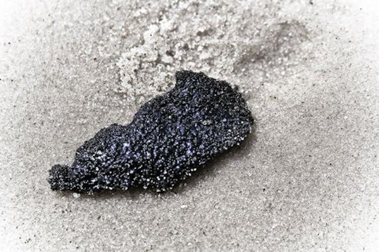 a large irregular black blob on sand
