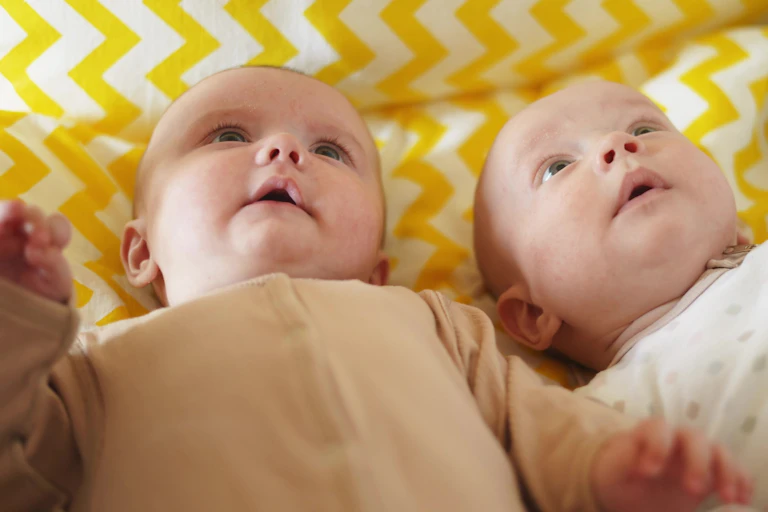 Two babies lying next to one another