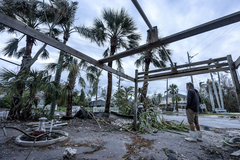 man looks at hurricane debris