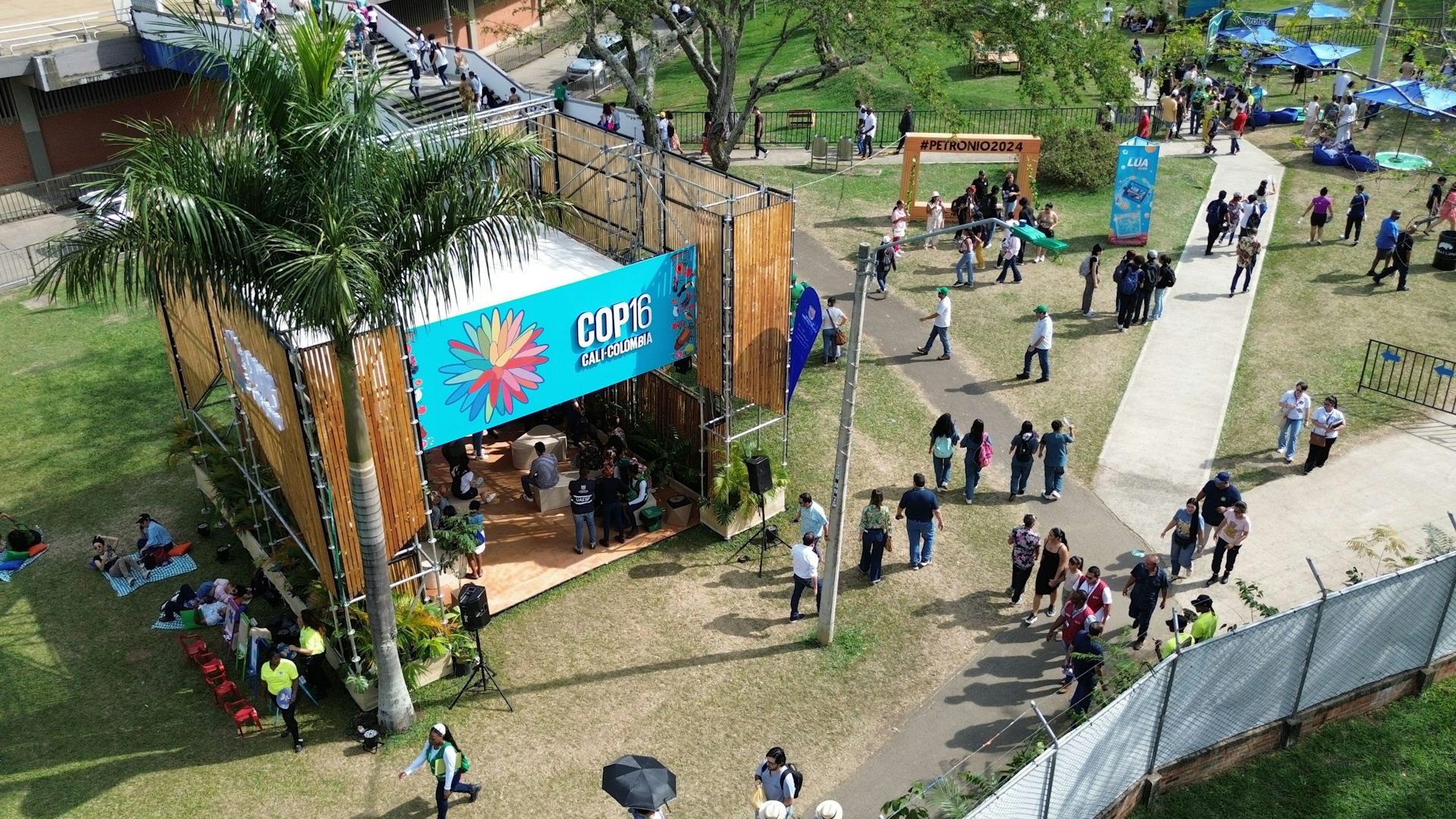 An aerial view of a booth with a 'COP 16' sign in a public park.