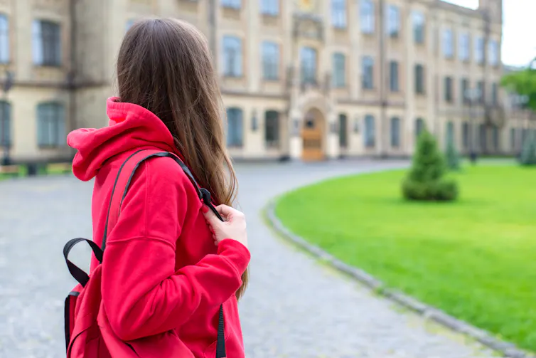 A women carrying a backpack seen from behind.