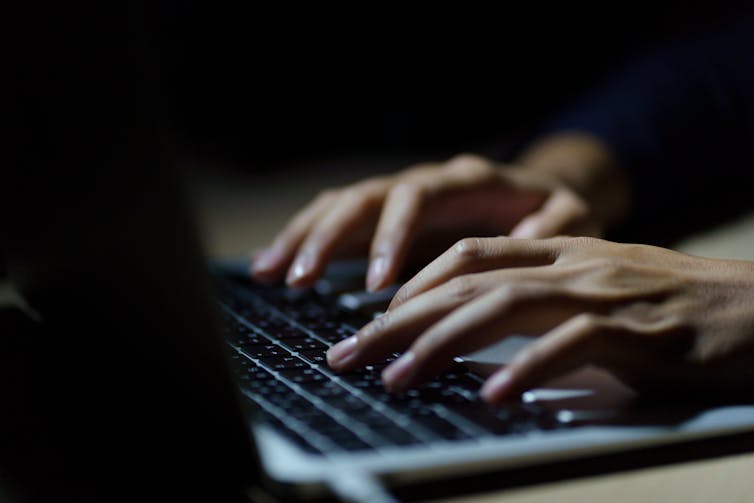 Close up of a person's hands typing on a keyboard