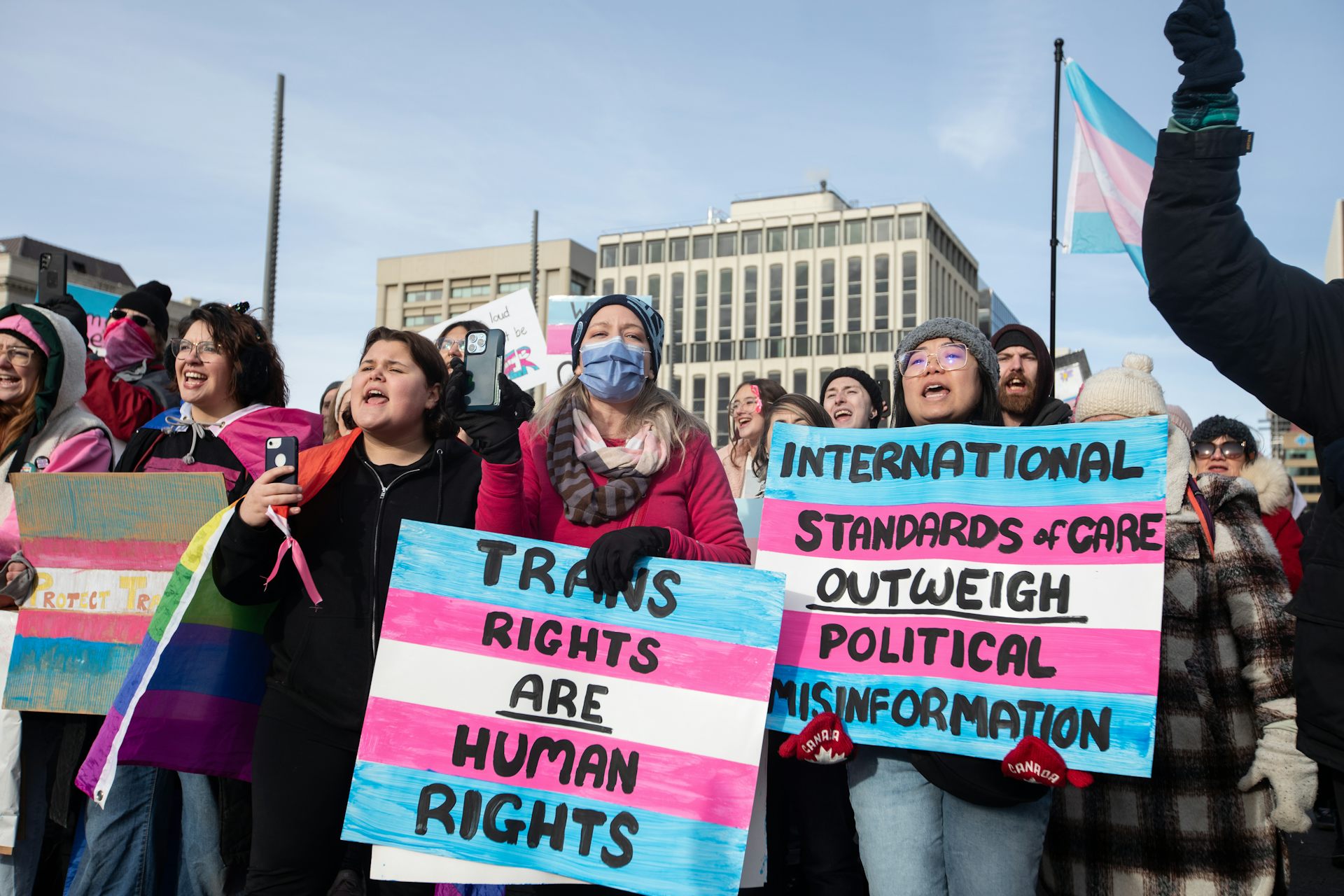 protesters hold up signs 'trans rights are human rights.'