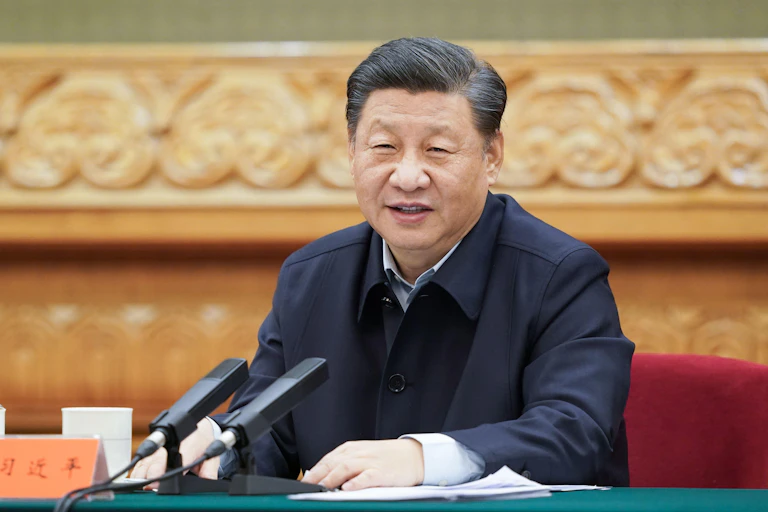 China's President Xi sitting at a desk.