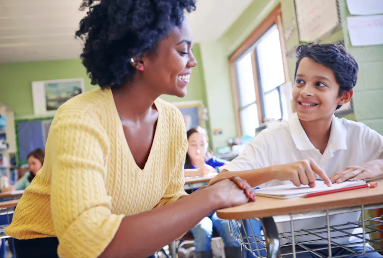 Smiling teacher helping student