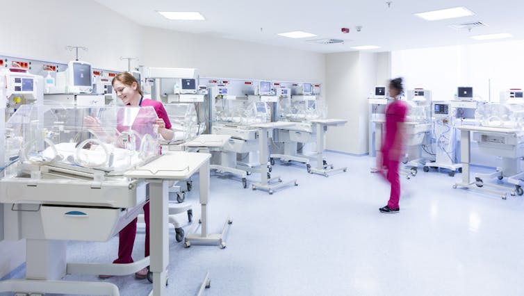 Newborns and nurses in a neonatal intensive care unit