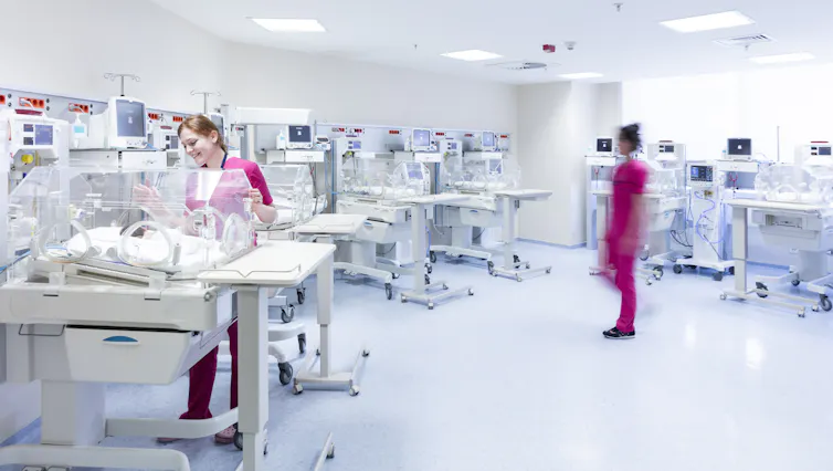 Newborns and nurses in a neonatal intensive care unit