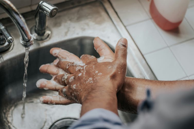 Pair of hands washing with soap and water