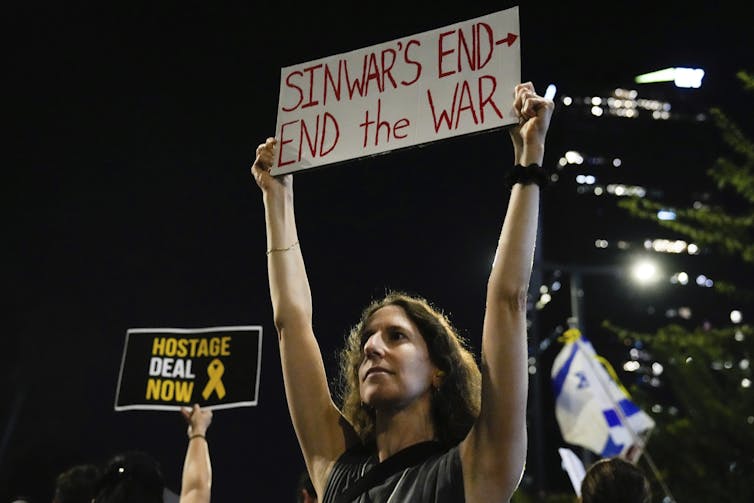 Una manifestante israelí sostiene una pancarta en la que se lee fin de la guerra