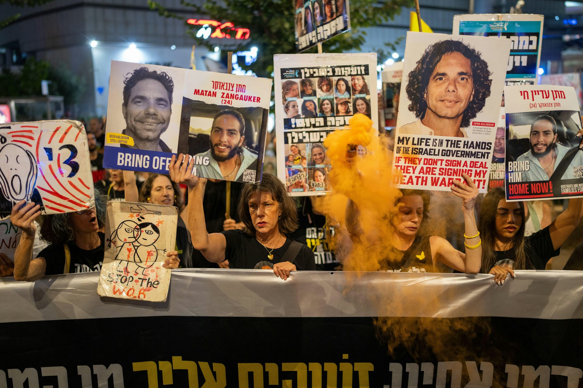 Crowd of protestors hold banners calling on the Israeli government to secure the release of their loved ones.